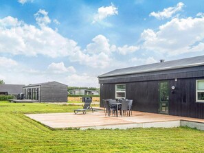 Een modern gebouw met een terras en buitenmeubilair.
