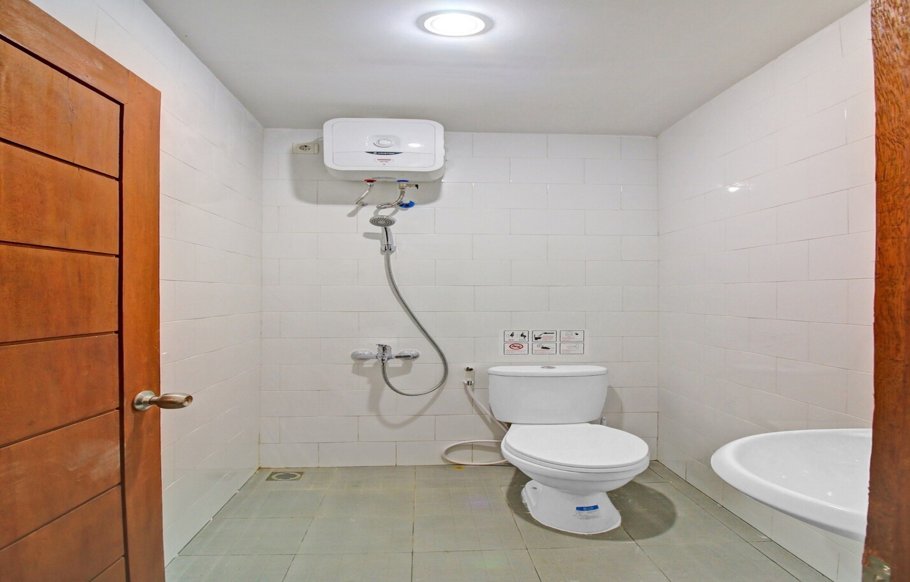 A small bathroom with a toilet, a shower, and a sink.