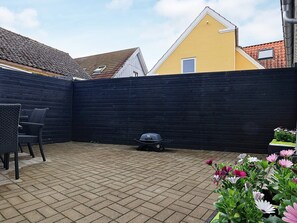 A patio area with a black fence, a grill, and outdoor furniture. - 6 Person Holiday Home in Hals (Hals)