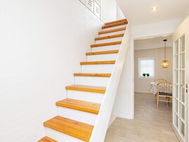 A staircase with wooden steps leading to a room with a table and chairs.