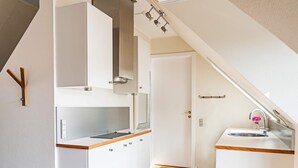 Eine moderne Küche mit weißen Schränken, einer Holz Arbeitsplatte und einem eingebauten Herd.