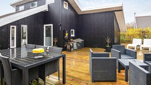 A modern outdoor deck with a dining area and seating. - 4 Person Holiday Home in Hemmet (Hemmet)