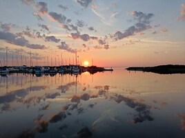 Un puerto deportivo con barcos amarrados al atardecer.
