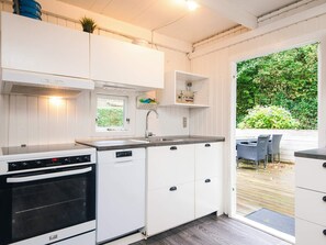 A compact kitchen with white cabinets, a built-in oven, and a window. - 4 Person Holiday Home in Hemmet (Hemmet)