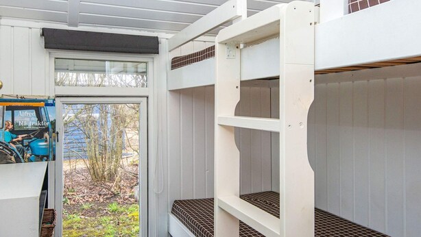 A bunk bed with a window, a door, and a small table with a basket. - 4 Person Holiday Home in Hemmet (Hemmet)