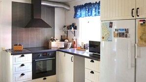Une cuisine compacte équipée d’une cuisinière, d’un four, d’un four à micro-ondes et d’un réfrigérateur.