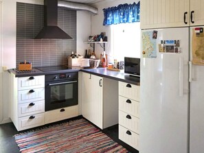 Une cuisine compacte équipée d’une cuisinière, d’un four, d’un four à micro-ondes et d’un réfrigérateur.