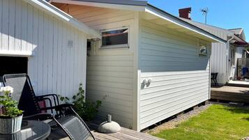 A single-story house with a covered porch, a small attached garage, and a deck area.