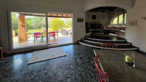 Ein geräumiges Zimmer mit einer großen Schiebeglastür, die zu einer Terrasse führt.