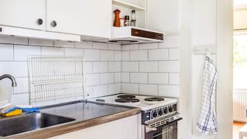 A kitchen with white cabinets, a stove, and a sink.