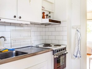 Une cuisine avec des meubles blancs, une cuisinière et un évier.