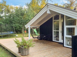A wooden deck with a covered patio area, a trampoline, and a green slide. - 6 Person Holiday Home in Hals (Hals)