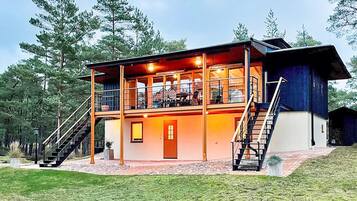 A two-story building with a balcony, stairs, and a door.