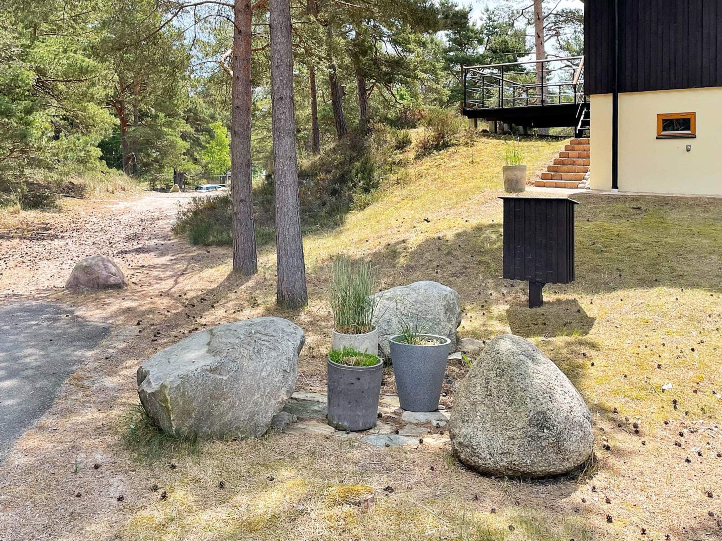 A modern building with a stone pathway leading to a wooden deck.