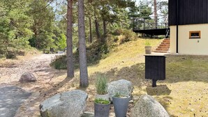Un bâtiment moderne avec un chemin de pierre menant à une terrasse en bois.