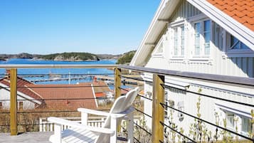 A white building with a red-tiled roof overlooking a marina.