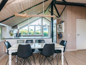 A modern kitchen with a large island, black chairs, and a dining table. - 7 Person Holiday Home in Hejls (Hejls)
