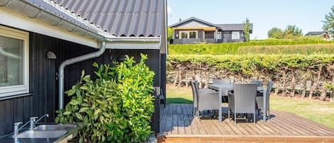 Une maison moderne dotée d’une cuisine, d’un espace extérieur aménagé et d’un jardin.