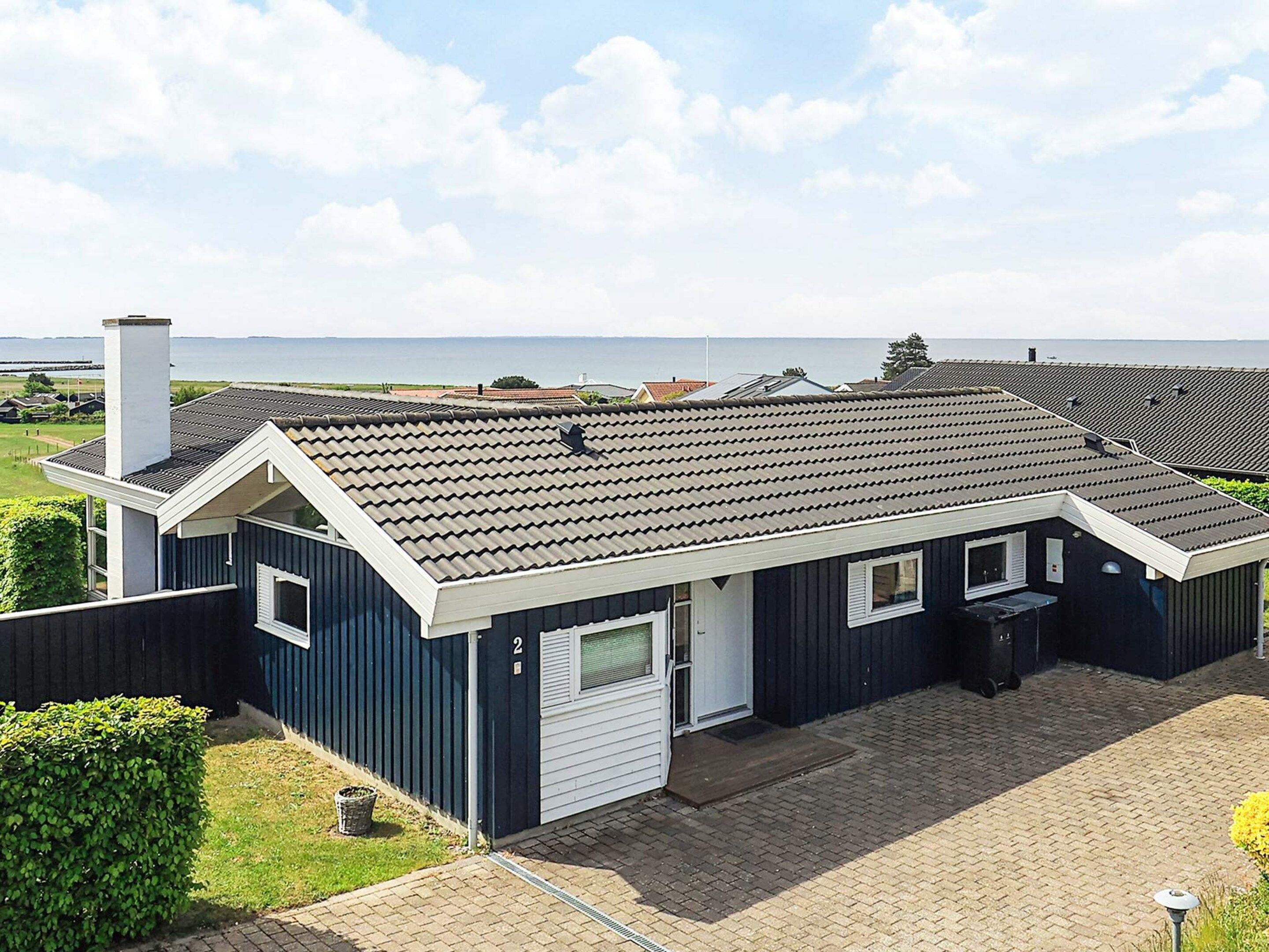 A single-story house with a dark blue exterior, a white garage door, and a tiled roof.