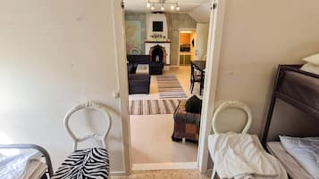 Habitación de hotel con cama, una silla, una mesita y vista al área de estar.