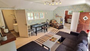 A living room with a sofa, a coffee table, and a dining area with a table and chairs. - 5 Person Holiday Home in Haltorp (Halltorp)