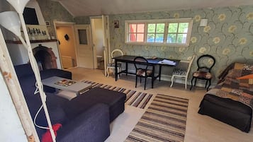 Una sala de estar con un sofá, una mesa de comedor con sillas, una chimenea y un ventanal con vistas al exterior.