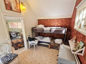 A compact room with bunk beds, a small table, a chair, and a radiator. - 5 Person Holiday Home in Haltorp (Halltorp)