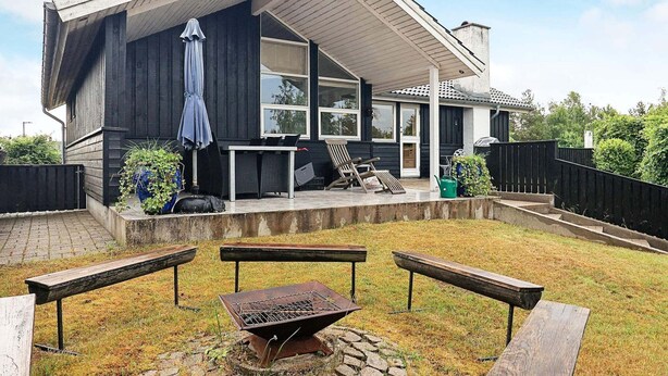 A modern house with a covered patio, outdoor seating, and a barbecue grill. - 6 Person Holiday Home in Hals (Hals)