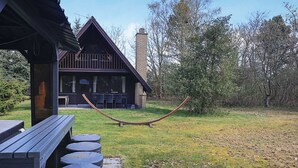 A rustic cabin with a deck, outdoor seating, and a swing. - 6 Person Holiday Home in Hals-by Traum (Hals)