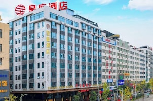A multi-story hotel with a modern facade, large windows, and a prominent signage at the top.