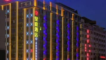 A hotel with illuminated signage and vertical light strips.