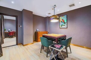 Un comedor con una mesa, sillas, una lámpara colgante y un cuadro en la pared.