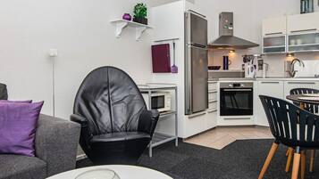 A compact living space with a kitchenette, a dining area, and a seating area.