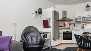 A compact living space with a kitchenette, a dining area, and a seating area.