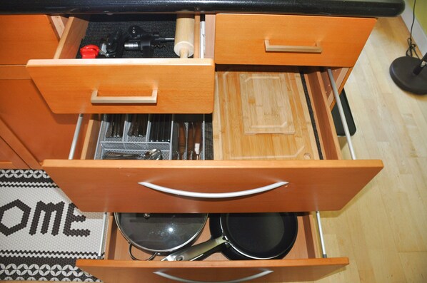 Un cajón de cocina con utensilios y utensilios de cocina.