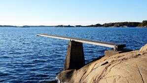 A pier extending into a calm body of water with a clear sky above. - 4 Person Holiday Home in Lur (Lur)