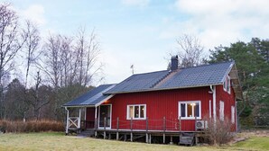 A red wooden house with a porch and a chimney. - 4 Person Holiday Home in Lur (Lur)