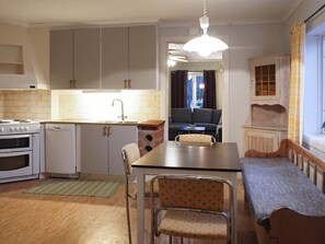 A compact kitchen with a dining area, a built-in oven, a sink, and a bench by the window. - 4 Person Holiday Home in Lur (Lur)