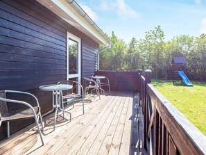 A wooden deck with outdoor furniture, a slide, and a playhouse. - 10 Person Holiday Home in Logstor (Logstor)