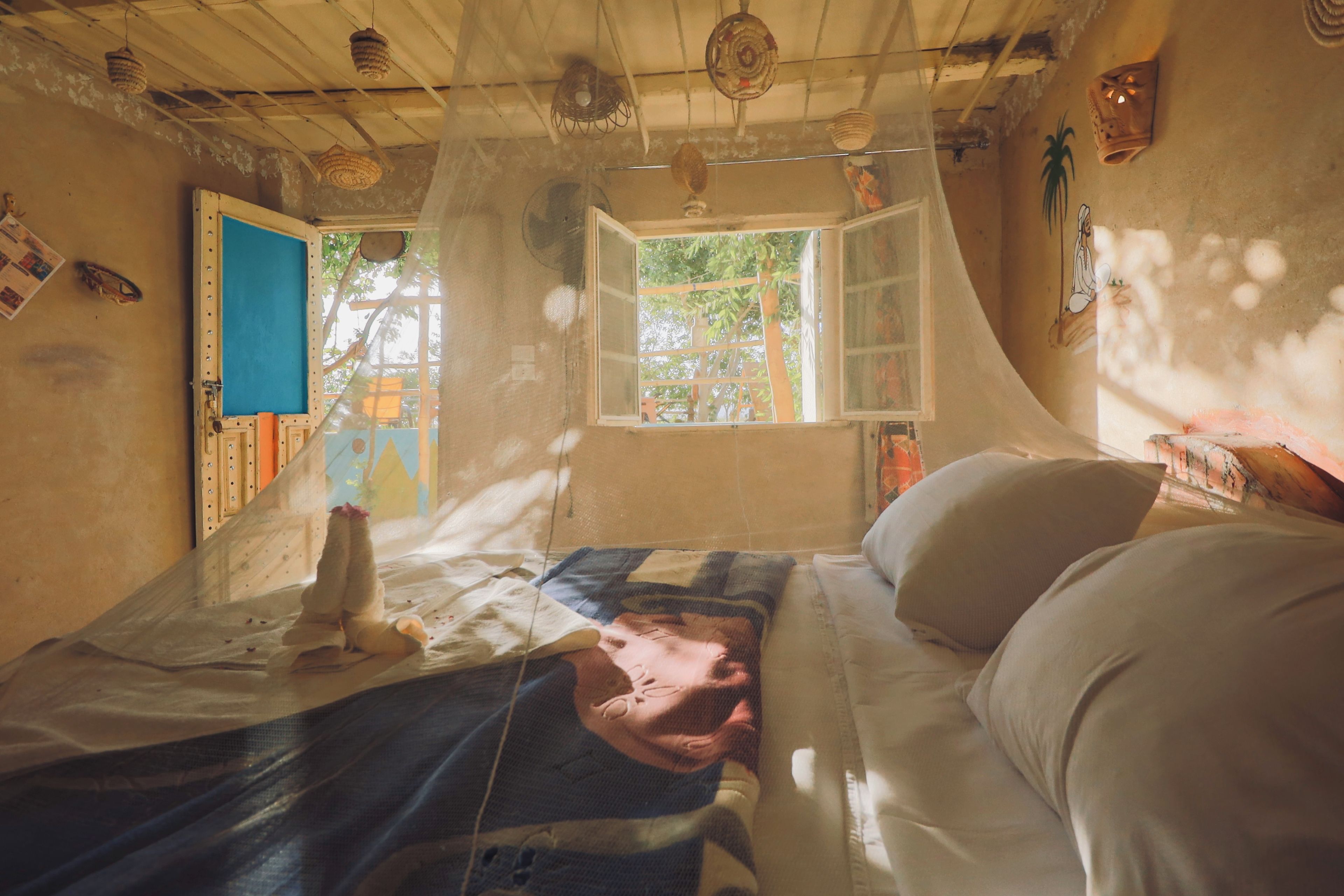 A room with a bed, a window, and a door.