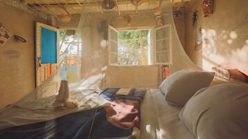 A room with a bed, a window, and a door.