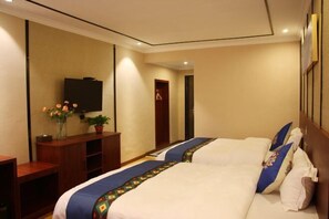A hotel room with two beds, a TV, a wooden cabinet, and a mirror. - Dongyulou Hotel (Jishou University Zhangjiajie Campus) (Zhangjiajie)