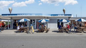 Espaces extérieurs aménagés avec des parasols, un restaurant situé en bord de plage et des cornets de glace.