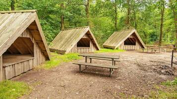 Um camping com cabanas de madeira e mesas para piquenique.