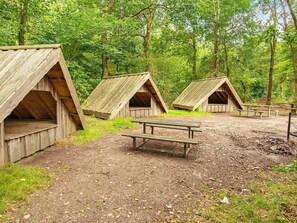 Un terrain de camping doté de cabanes en bois et de tables de pique-nique.