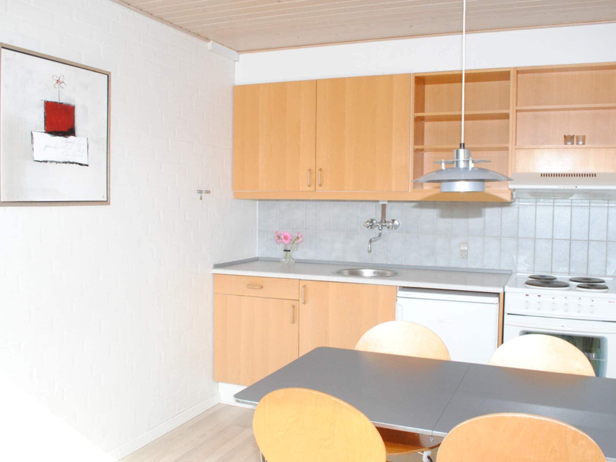 Una cocina moderna con gabinetes de madera, un lavamanos de acero inoxidable y una estufa a gas.