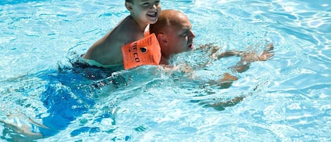 Une piscine avec une eau d’un bleu limpide et de légères ondulations visibles à la surface.