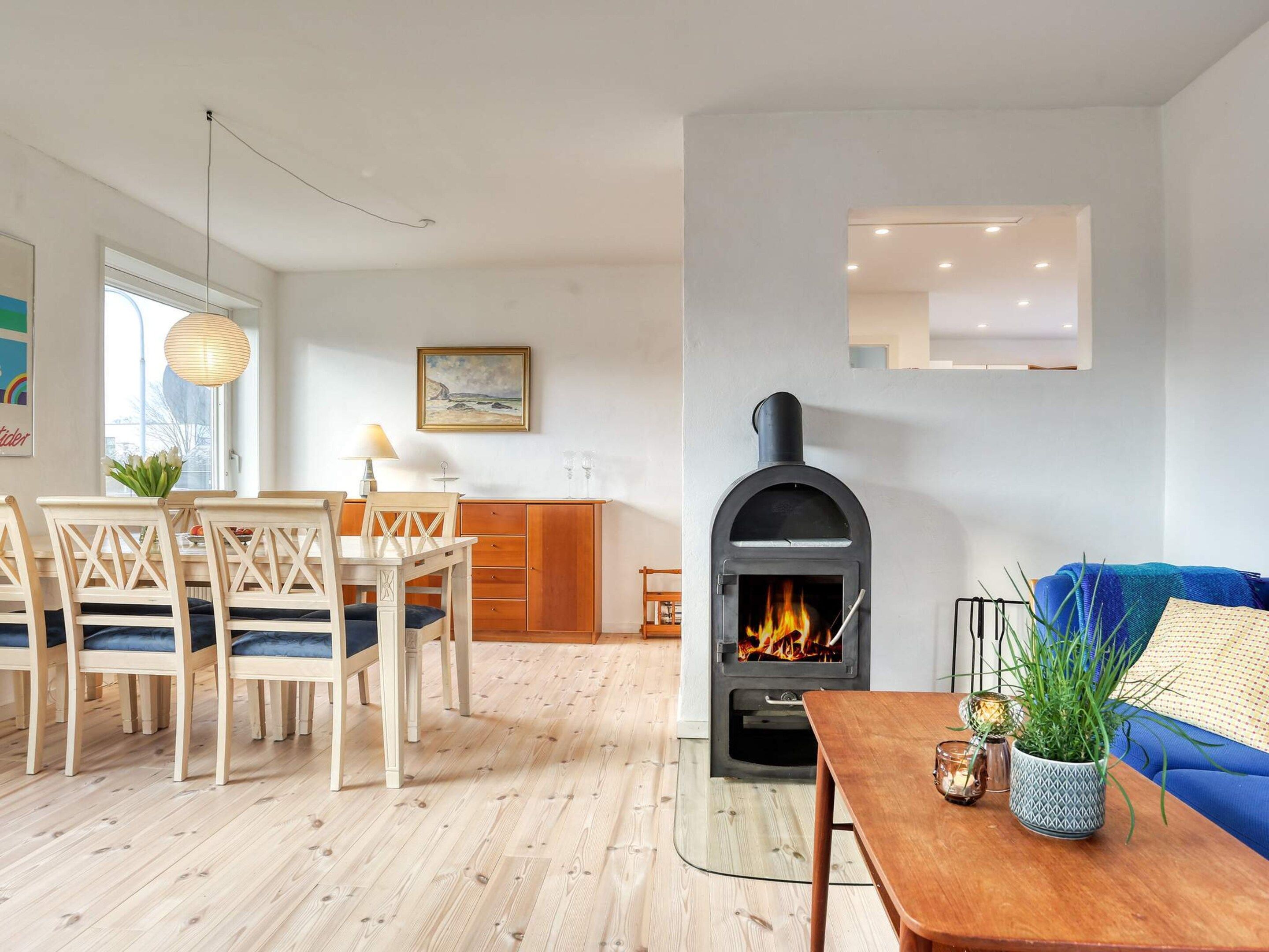 A modern living room with a fireplace, wooden furniture, and a blue sofa.