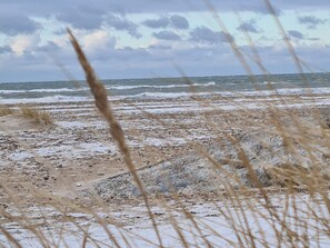 A beach with rough sea waves and overcast sky. - 6 Person Holiday Home in Strandby (Strandby)