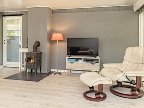 A living room with a fireplace, a television, and a leather armchair.